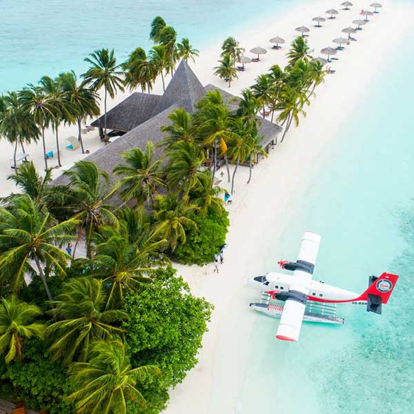 A sea plane parked up on a remote white sand beach in the maldives